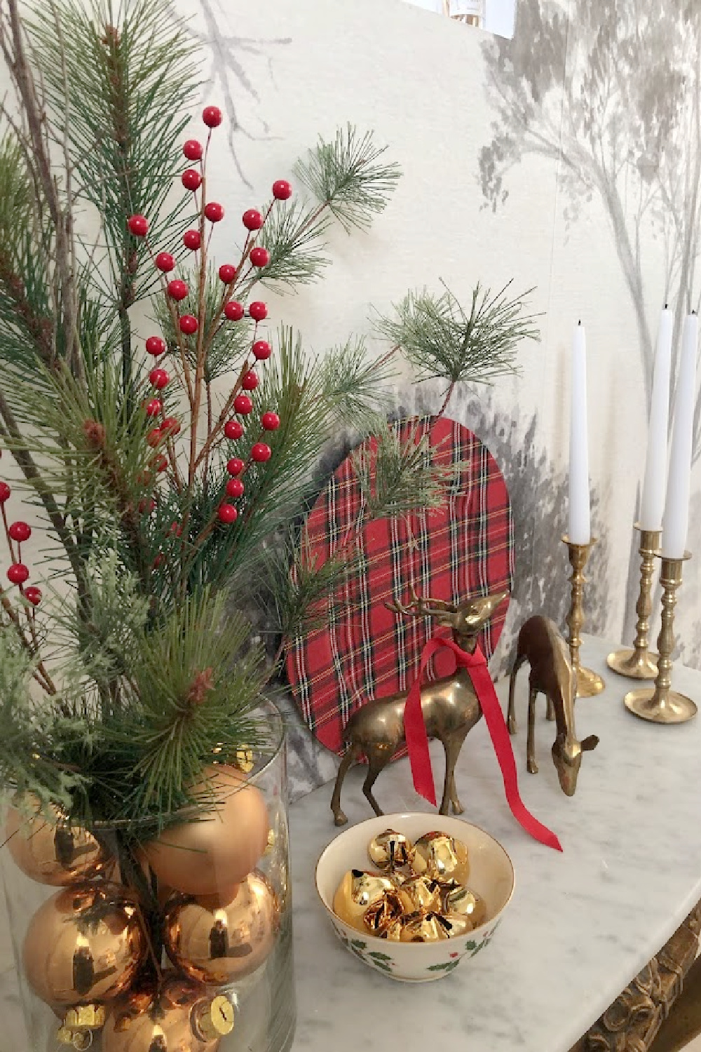 French antique console table decorated for Christmas in entry with grisaille tree wallpaper mural - Hello Lovely Studio. #modernfrench #frenchchristmas