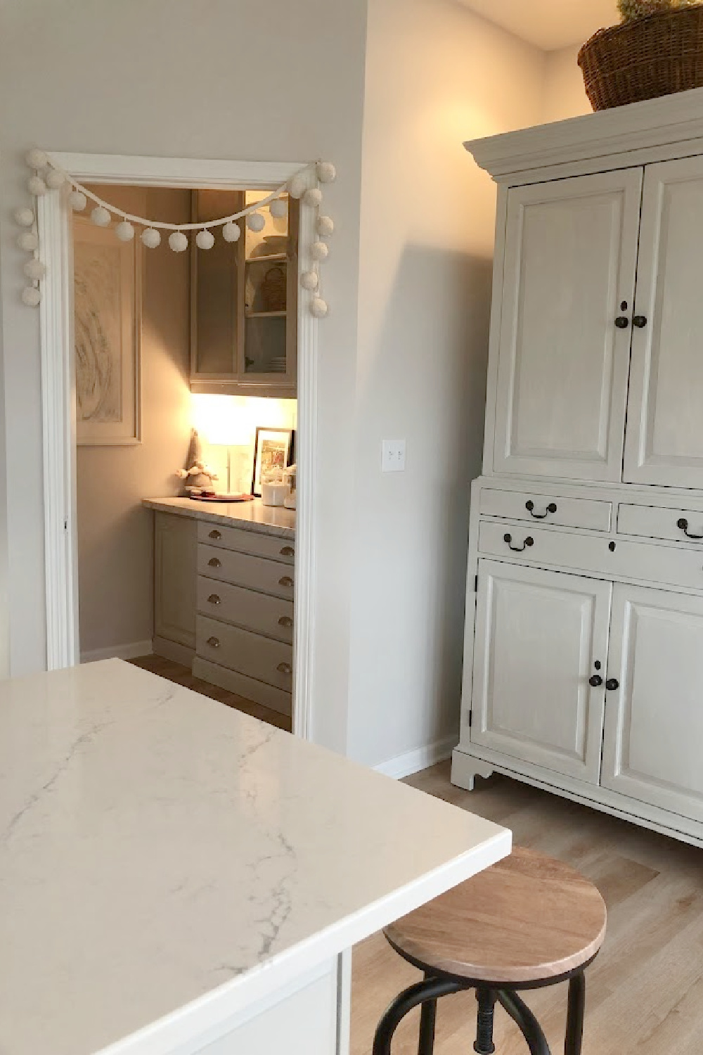 View into pantry with pom pom garland for Christmas - Hello Lovely Studio. #christmaskitchen