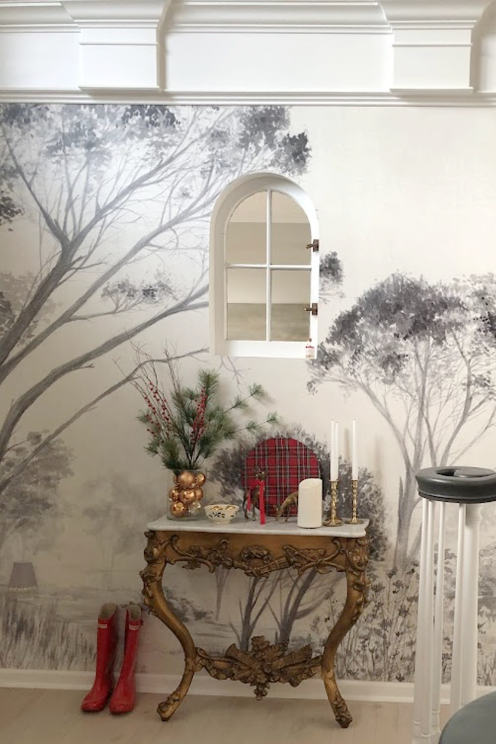 French antique console table decorated for Christmas in entry with grisaille tree wallpaper mural - Hello Lovely Studio. #modernfrench #frenchchristmas