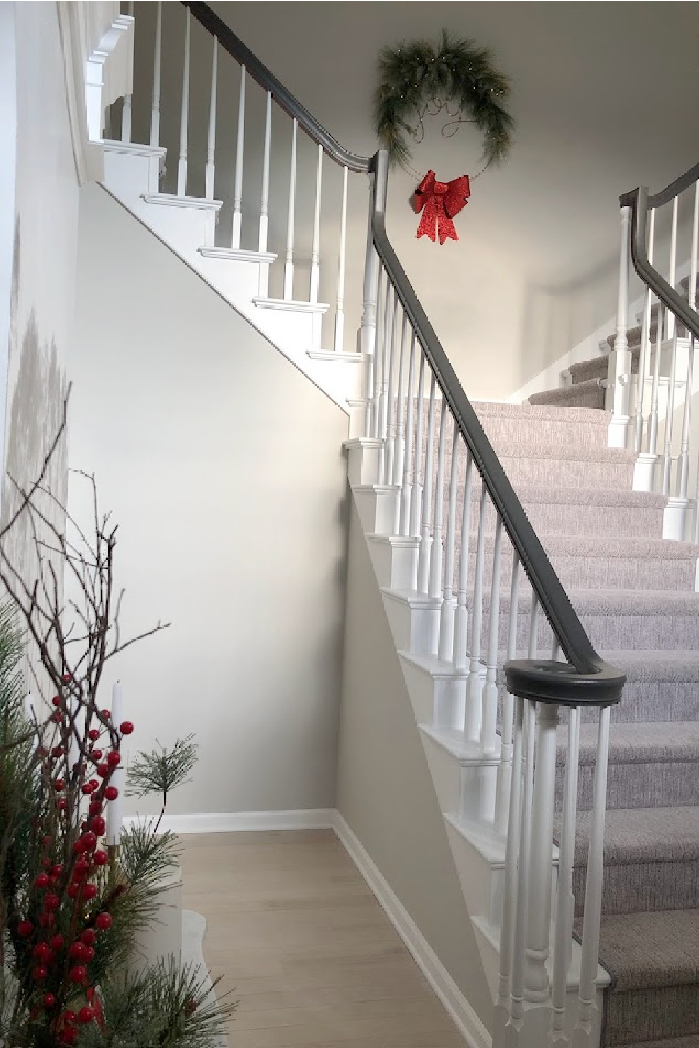 Prelit joy wreath at top of staircase - Hello Lovely Studio. #holidaywreath #joywreath