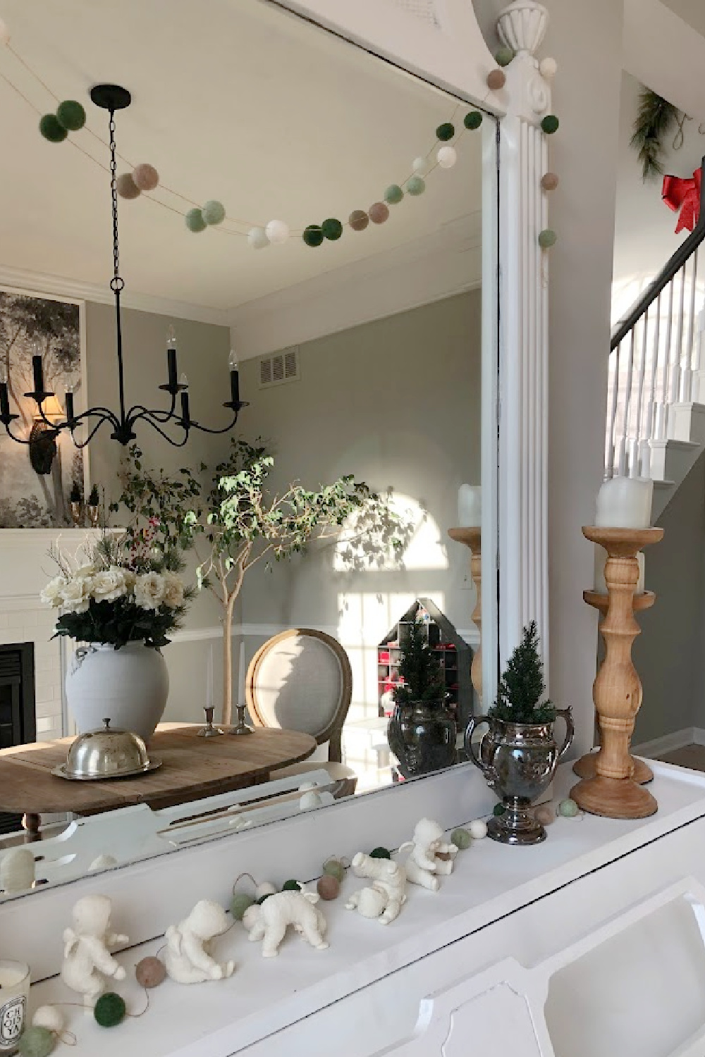 Our dining room with fireplace is used as a music room where a white piano and antique mirror are decorated for Christmas in white - Hello Lovely Studio. #whitechristmas #whitepiano