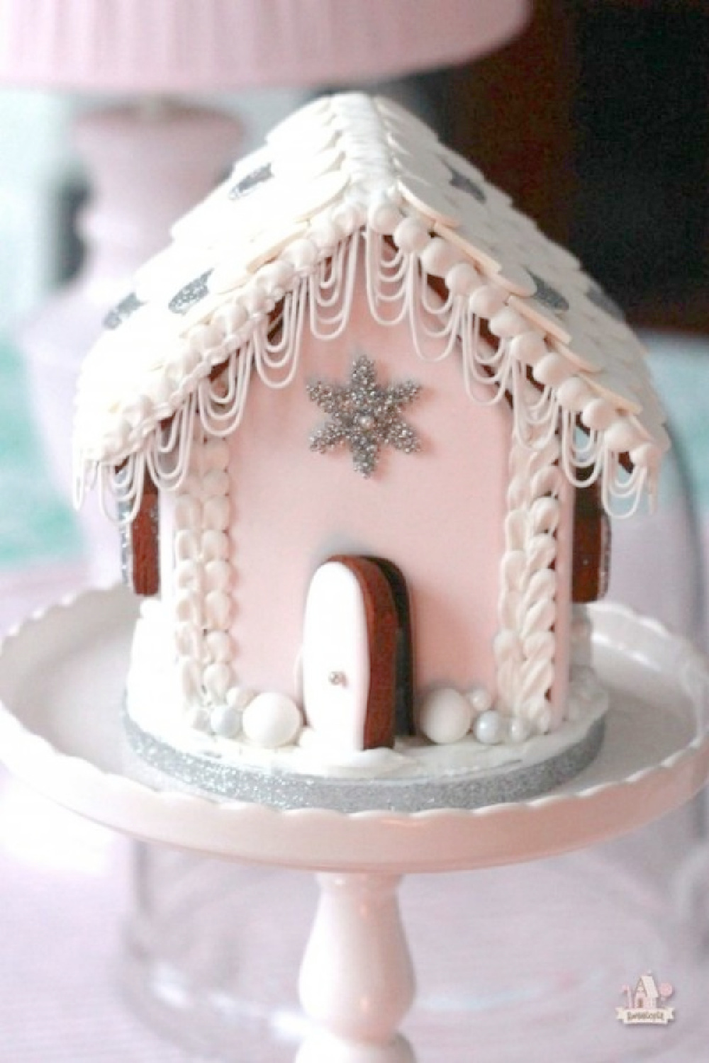 Pink Christmas gingerbread house on a pedestal - Sweetopia. #gingerbreadhouse #pinkchristms