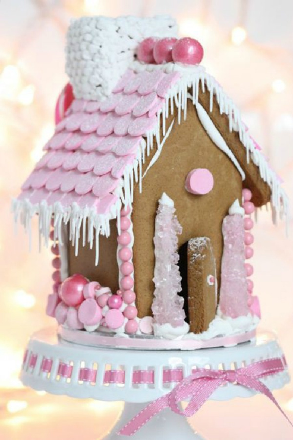 Charming pink accents on a gingerbread house cottage with pink rock candy trees. #gingerbreadhouse #pinkchristmas #holidaybaking