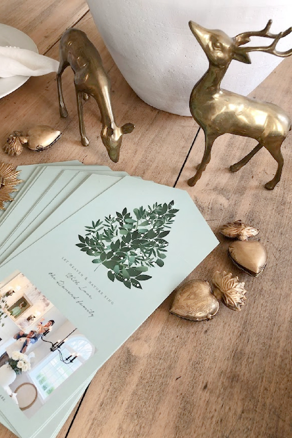 Minted photo Christmas card (Heaven and Nature Sing foldable design with perforated edge to remove photo) on dining room table with gold sacred milagros and vintage brass deer - Hello Lovely Studio. #mintedchristmascard