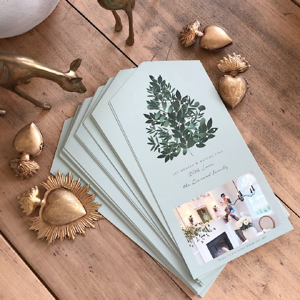 Our Minted Christmas card "Heaven and Nature Sing" (a foldable design with perforated edge to remove photo) on my dining room table with gold sacred milagro ornaments - Hello Lovely Studio. #mintedchristmascard