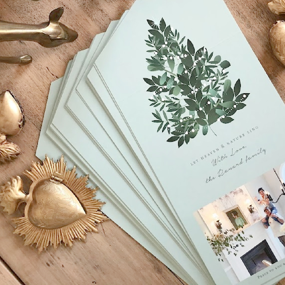 Minted photo Christmas card (Heaven and Nature Sing foldable design with perforated edge to remove photo) on dining room table with gold sacred milagros and vintage brass deer - Hello Lovely Studio. #mintedchristmascard