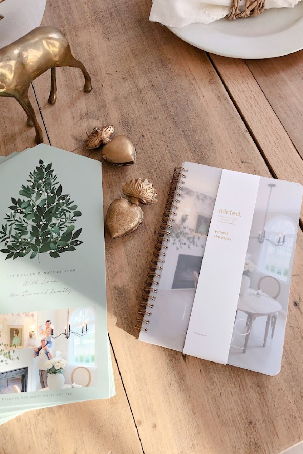 Customized photo notebook and Minted Christmas card "Heaven and Nature Sing" (a foldable design with perforated edge to remove photo) on my dining room table with gold sacred milagro ornaments - Hello Lovely Studio. #mintedchristmascard