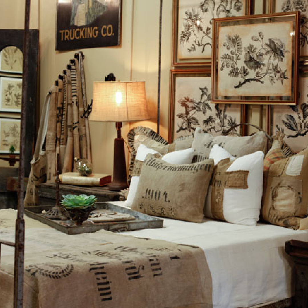 Beautiful Mess Home - Kymberley Fraser designed antique German grainsack pillows and throws on bed in shop. #antiquegrainsacks