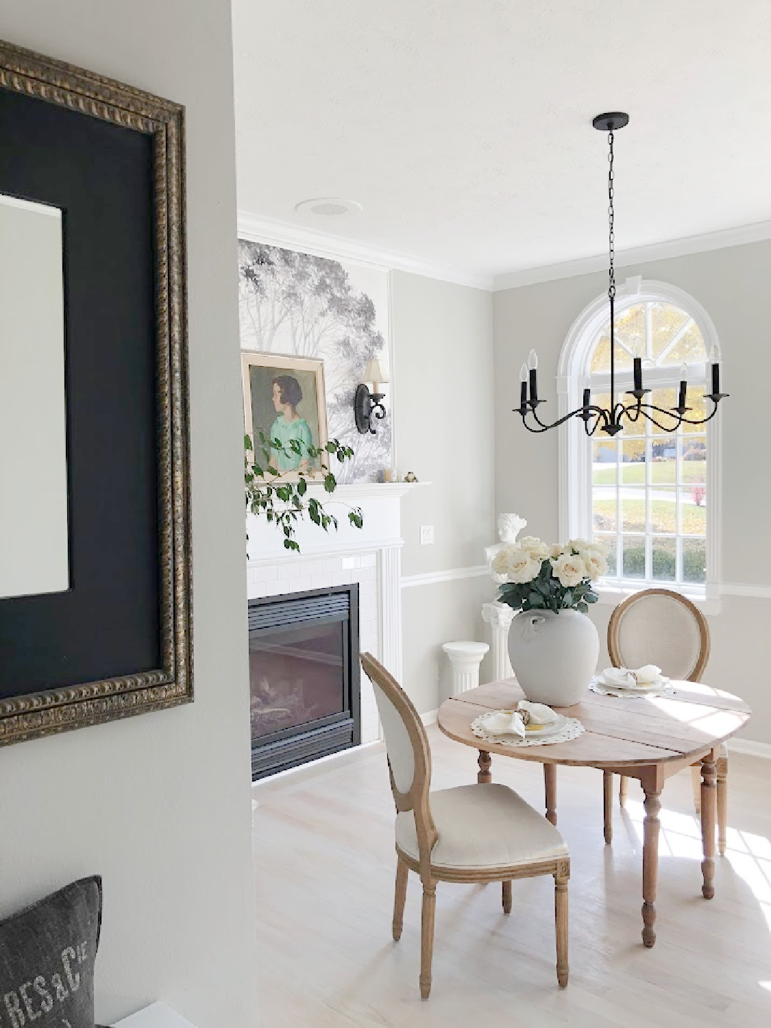 Dining room with antique table, Louis style chairs, fireplace with mural above, and SW Repose Gray paint color on walls - Hello Lovely Studio.