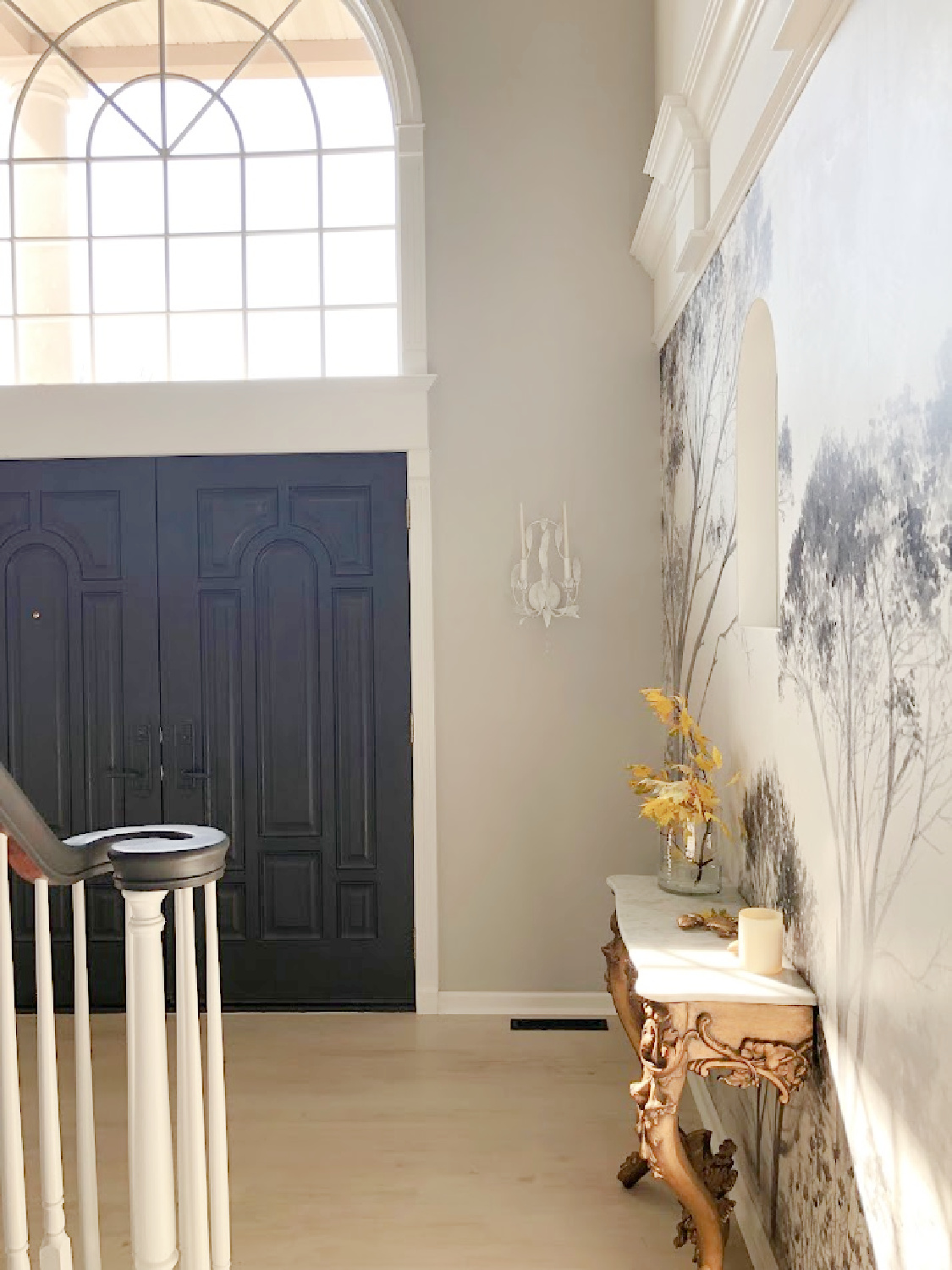 Renovated entry with dark gray doors (SW Carbonized), walls painted SW Repose Gray, tree mural (Photowall), and greyed oak hardwoods - Hello Lovely Studio.