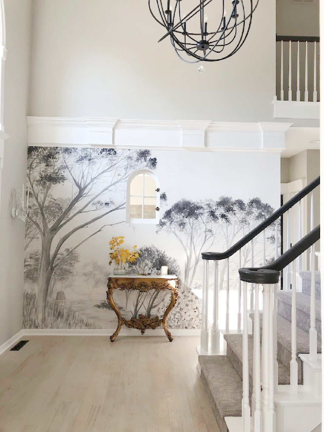 Renovated entry with dark gray doors (SW Carbonized), walls painted SW Repose Gray, tree mural (Photowall), and greyed oak hardwoods - Hello Lovely Studio.