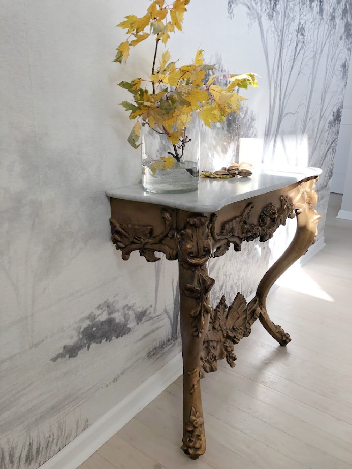 French antique console table in our entry with vase of yellow maple leaf branches - Hello Lovely Studio.