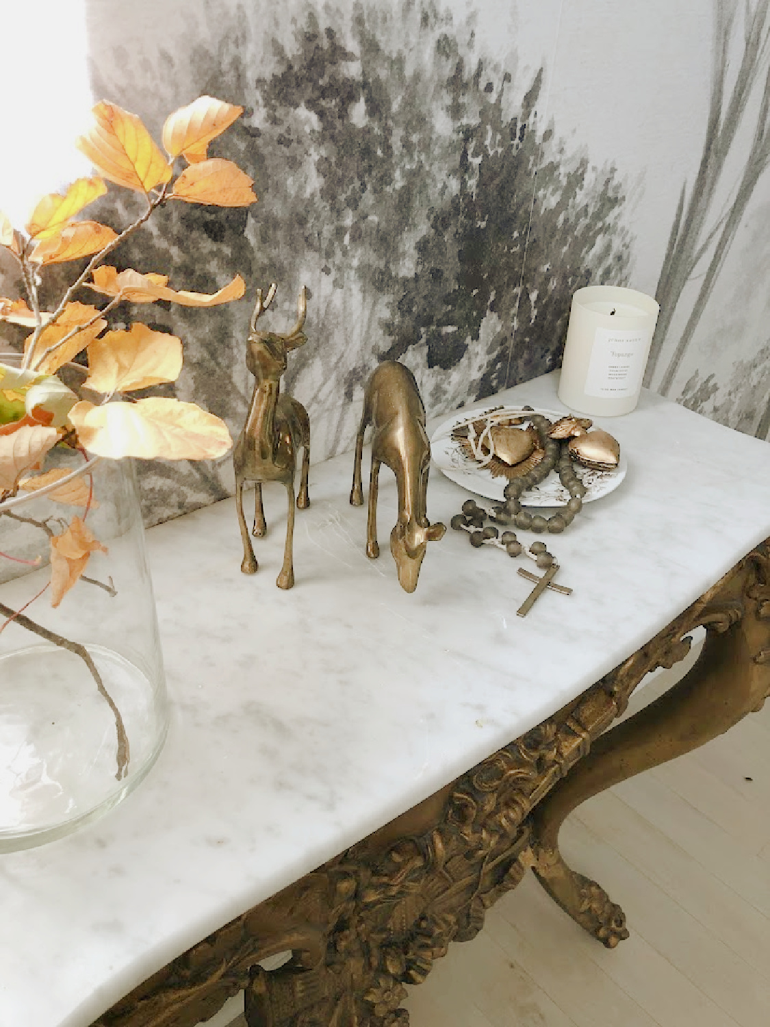 Vintage brass deer and fall branches in vase on marble console in entry - Hello Lovely Studio.