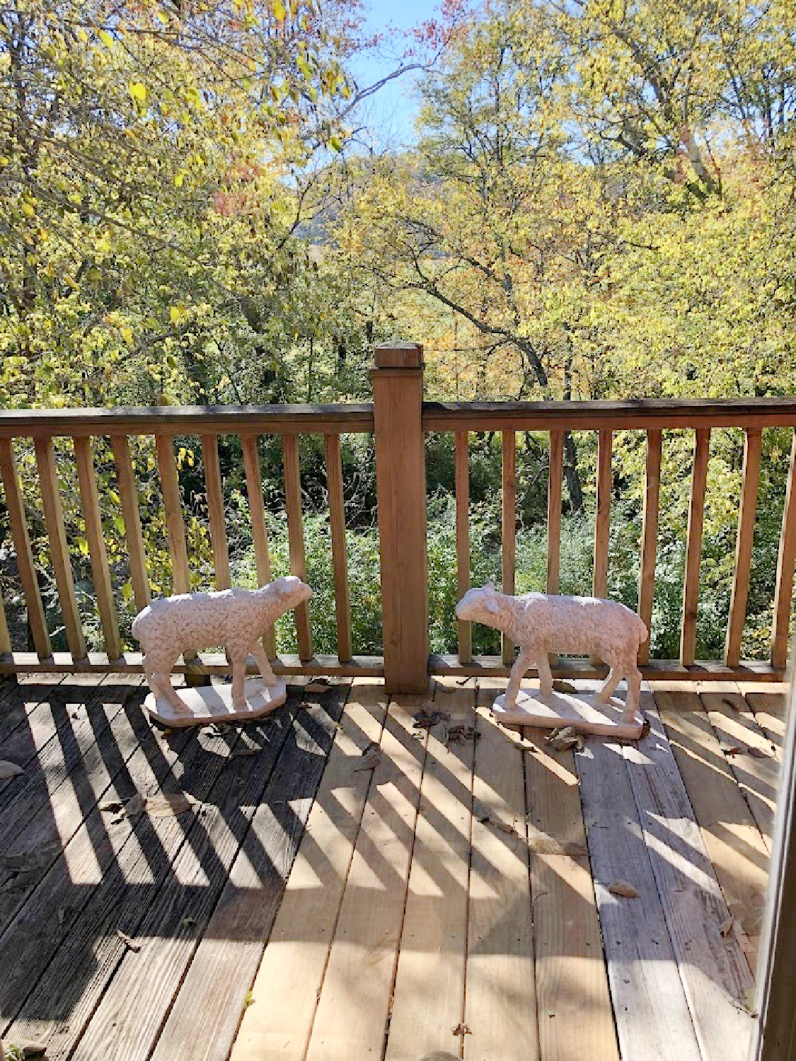 Standing lamb garden statues on back deck overlooking creek at Patina Home & Garden shop from Giannettis in Leiper's Fork, TN - Hello Lovely Studio. #patinahome #leipersforktn