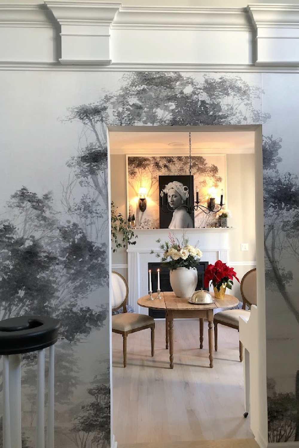 Holiday decor in our entry and dining room which feature a wallpapered tree mural, light grey stained floors, and a gentle quiet palette of serene hues - Hello Lovely Studio. #elegantchristmas #modernfrenchchristmas