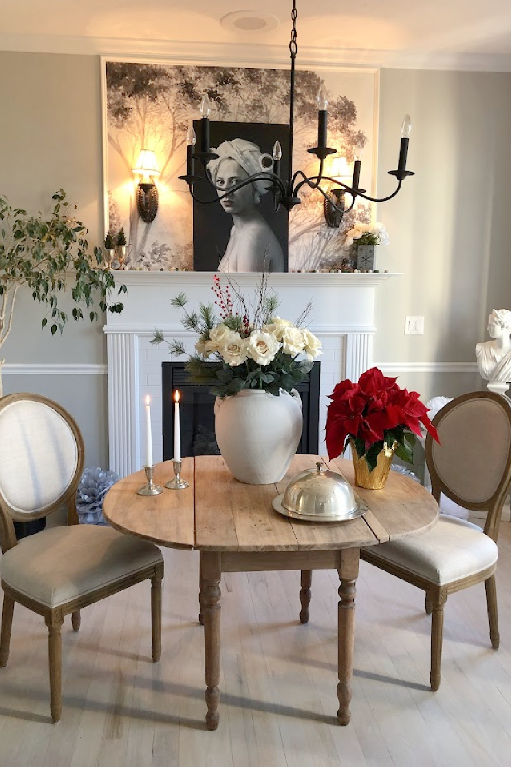 Holiday decor in our entry and dining room which feature a wallpapered tree mural, light grey stained floors, and a gentle quiet palette of serene hues - Hello Lovely Studio. #elegantchristmas #modernfrenchchristmas