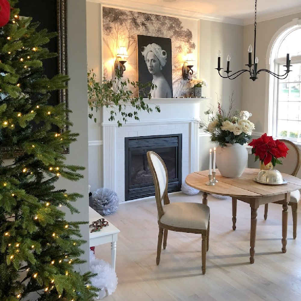 Holiday decor in our entry and dining room which feature a wallpapered tree mural, light grey stained floors, and a gentle quiet palette of serene hues - Hello Lovely Studio. #elegantchristmas #modernfrenchchristmas