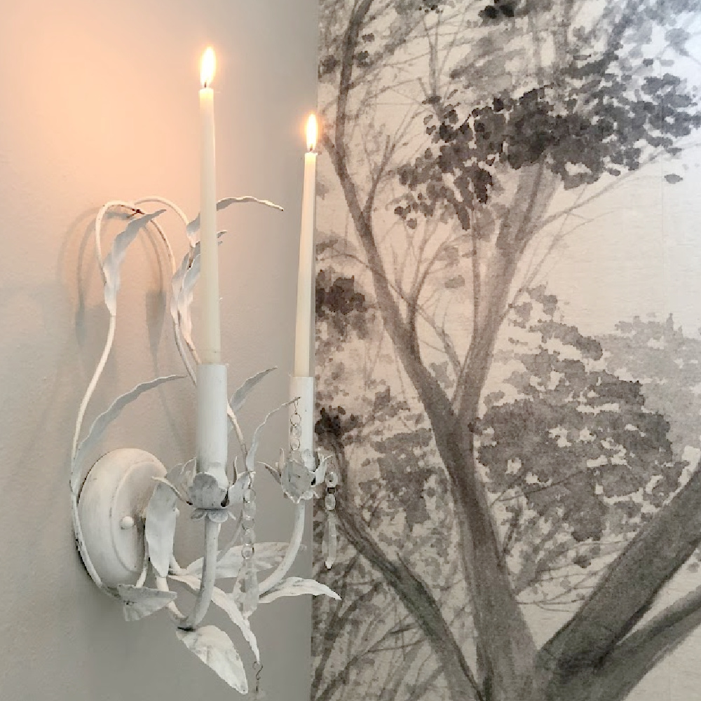 White and crystal candle sconces in our entry with wallpaper mural and walls painted Sherwin Williams Repose Gray.