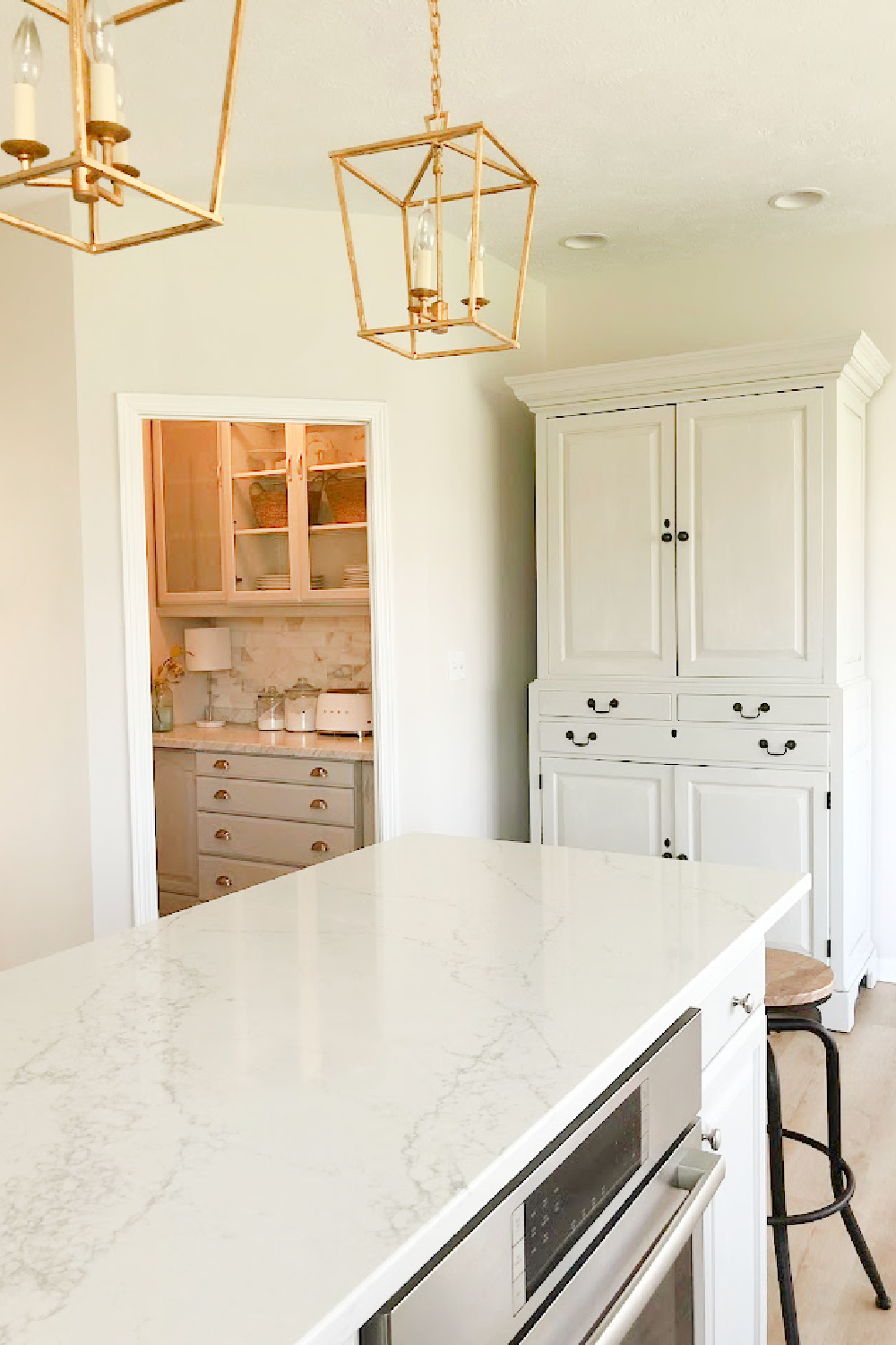 Renovated kitchen with Viatera Muse countertops and Sherwin Williams Eider White paint color. Cabinets are 50% Farrow & Ball Pavilion Gray - Hello Lovely Studio.