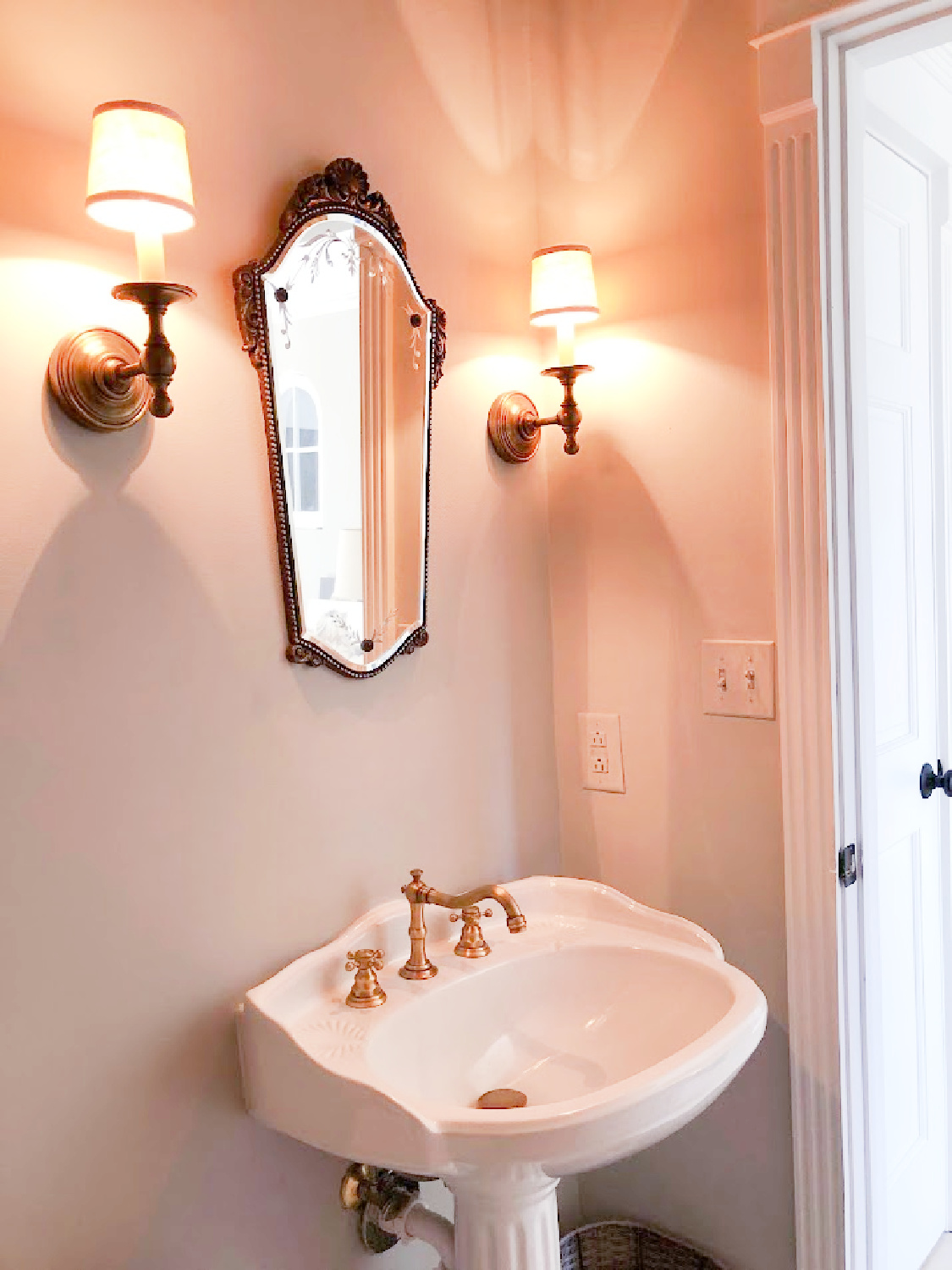 Vintage mirror and classic antique sconces in renovated powder bath - Hello Lovely Studio.