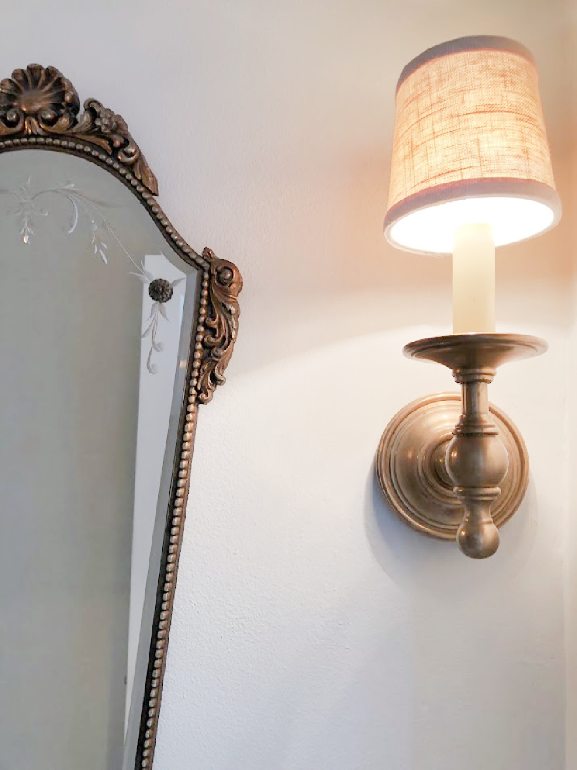Vintage mirror and antique brass sconce in renovated powder bath - Hello Lovely Studio.