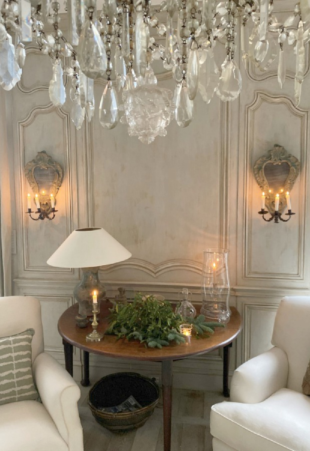 Beautiful Belgian style in an elegant paneled sitting area with white chairs and candle sconces - Greet Lefevre of Belgian Pearls. #belgianstyle #belgianchristmas