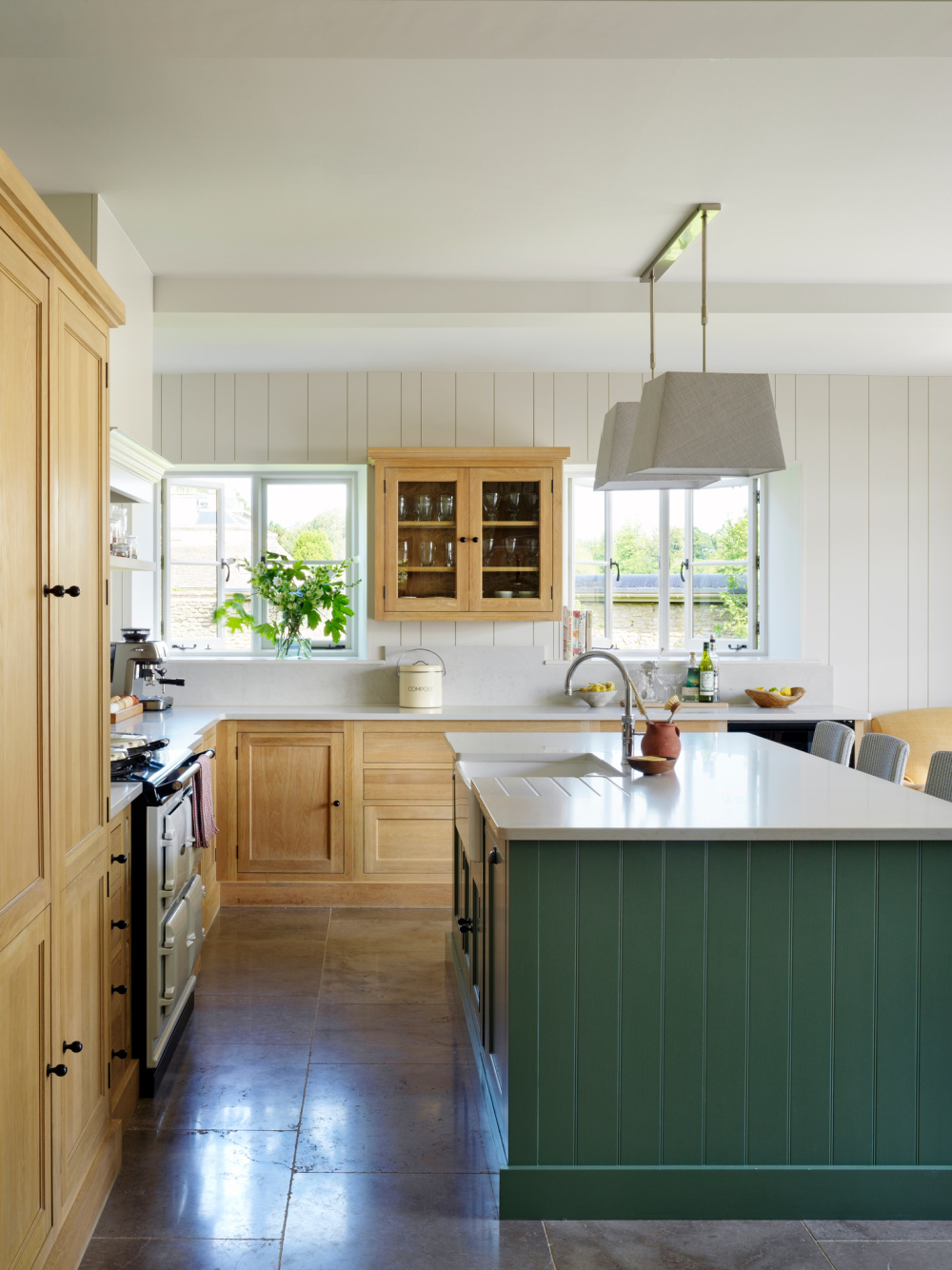 English Country kitchen with green island and design by Sims Hilditch in THE EVOLUTION OF HOME (Rizzoli, 2022).