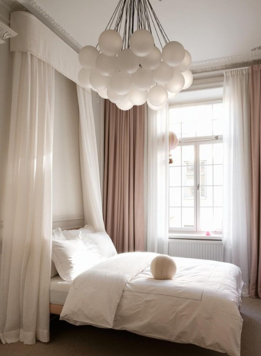 Luxurious Stockholm bedroom with canopy, blush pink drapes, and modern balloon chandelier. Design by Louis Hjorth. #stockholmapartment #luxuriousbedrooms #stockholmbedroom