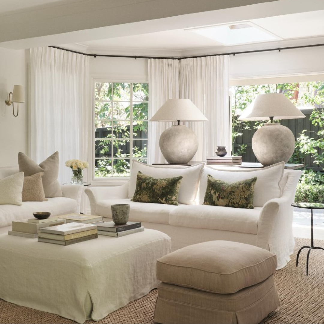 Casual minimal modern living room with white slipcovered furnishings and round lamps on console - @phoebenicol.interiors. #whitelivingrooms #slipcoveredfurniture