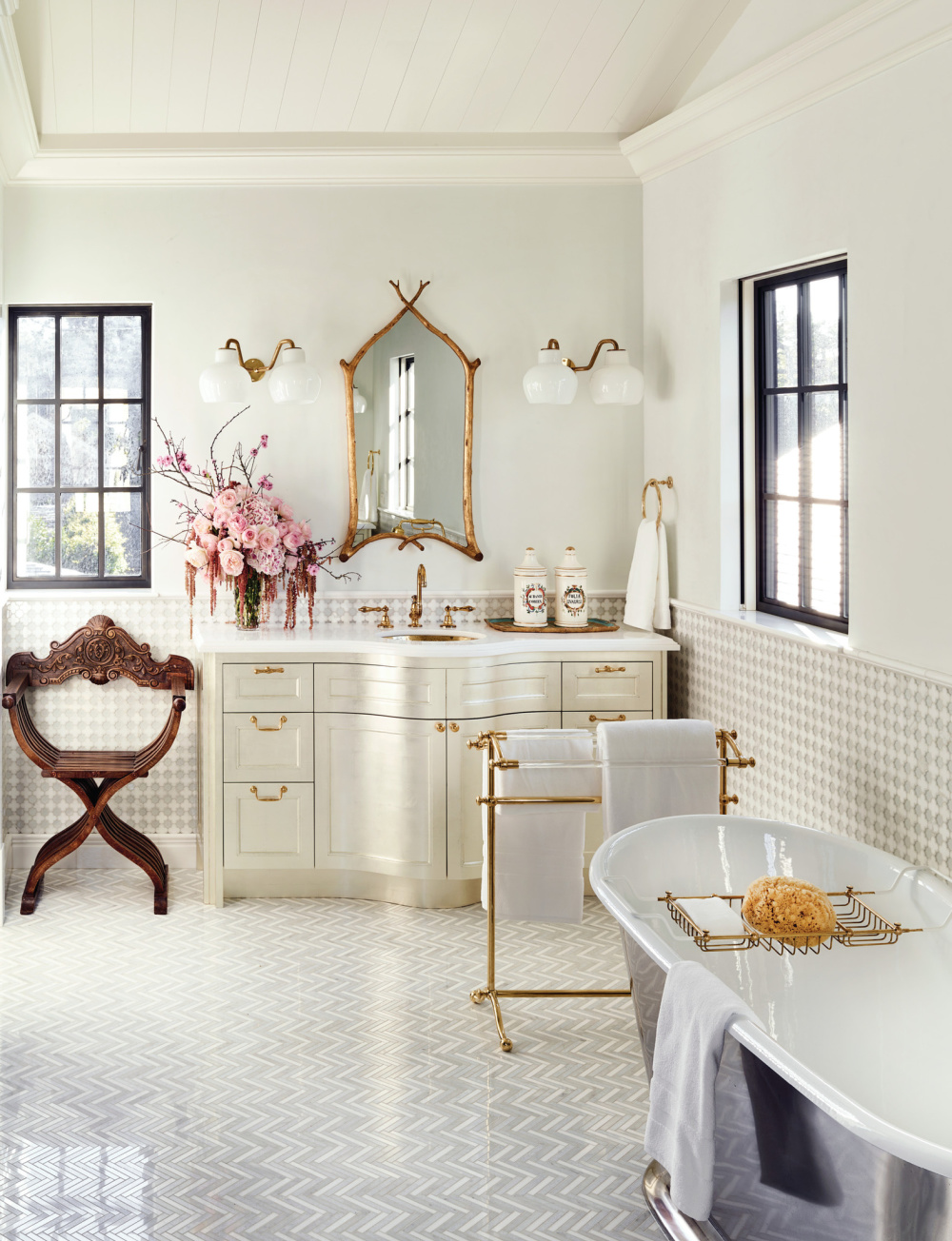 Elegant white bath with gold accents, clawfoot tub, and black windows - in THE ULTIMATE BATH by Barbara Sallick (Rizzoli, 2022).