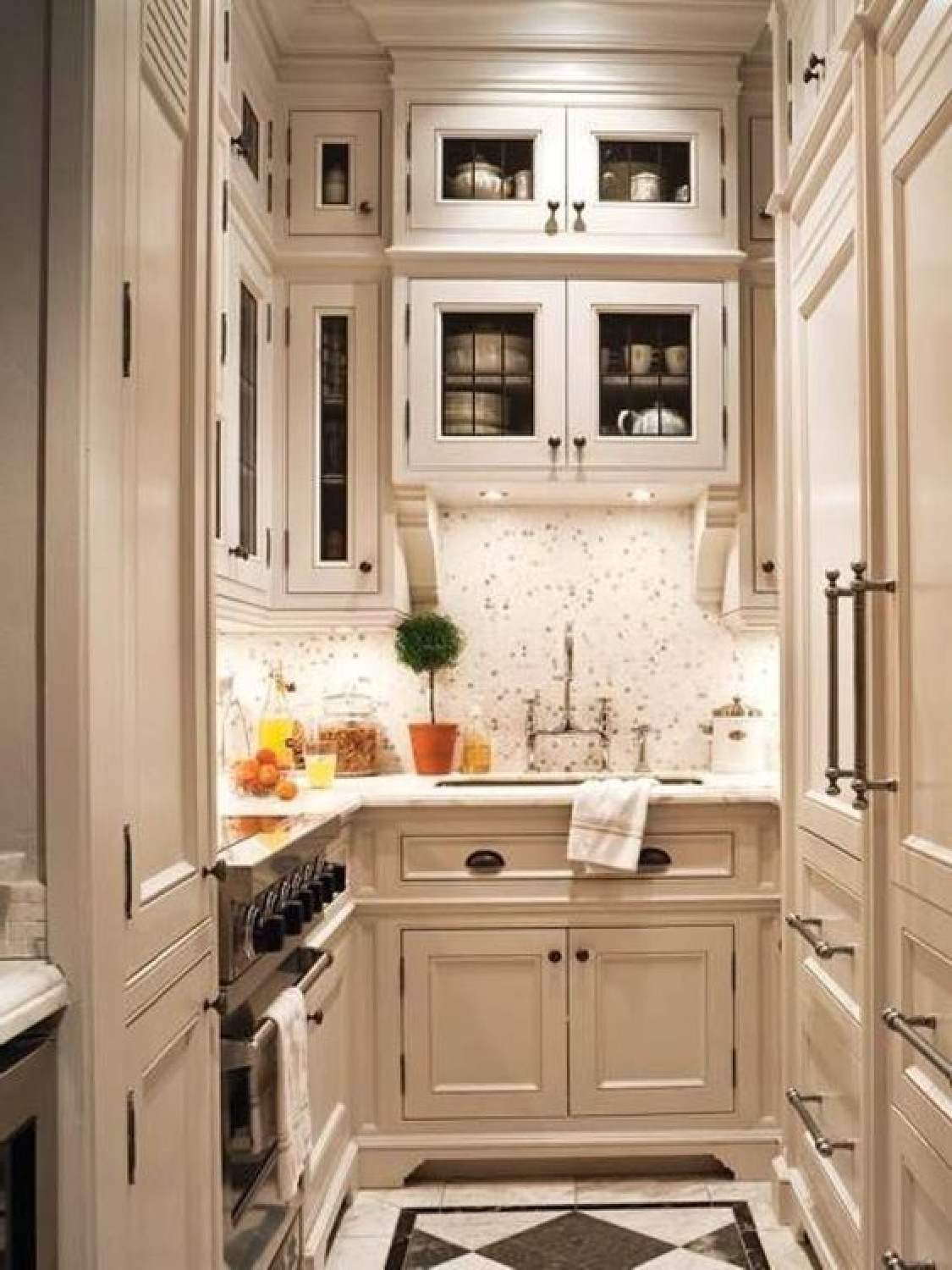 Small classic traditional kitchen with black and white flooring and two tiered upper cabinets taking advantage of every inch of vertical space. #smallkitchens #ushapekitchens #kitchendesign #cottagekitchens