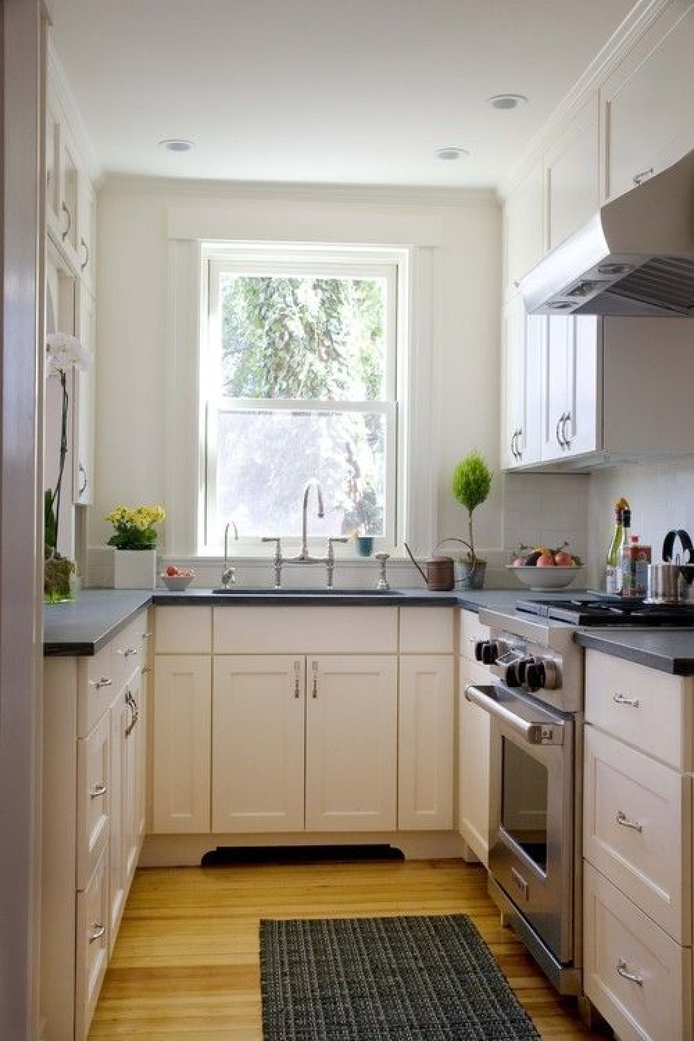 Come see these photos of lovely white classic traditional kitchens including this u-shaped one with dark counters. #kitchendesign #smallkitchen #cottagekitchens