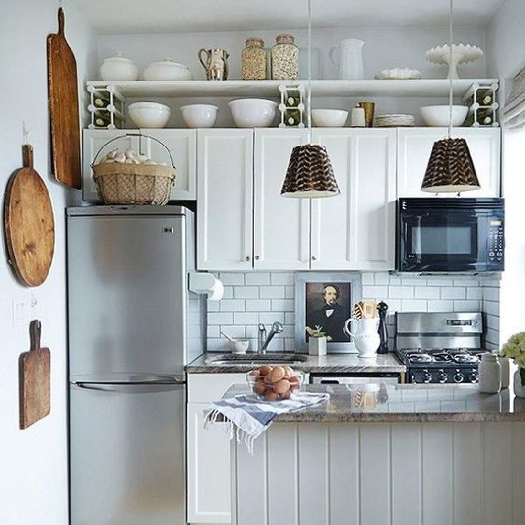 Small all-white kitchen with wood accents, open shelves and vertical storage. #smallkitchen #cottagekitchens #openshelves