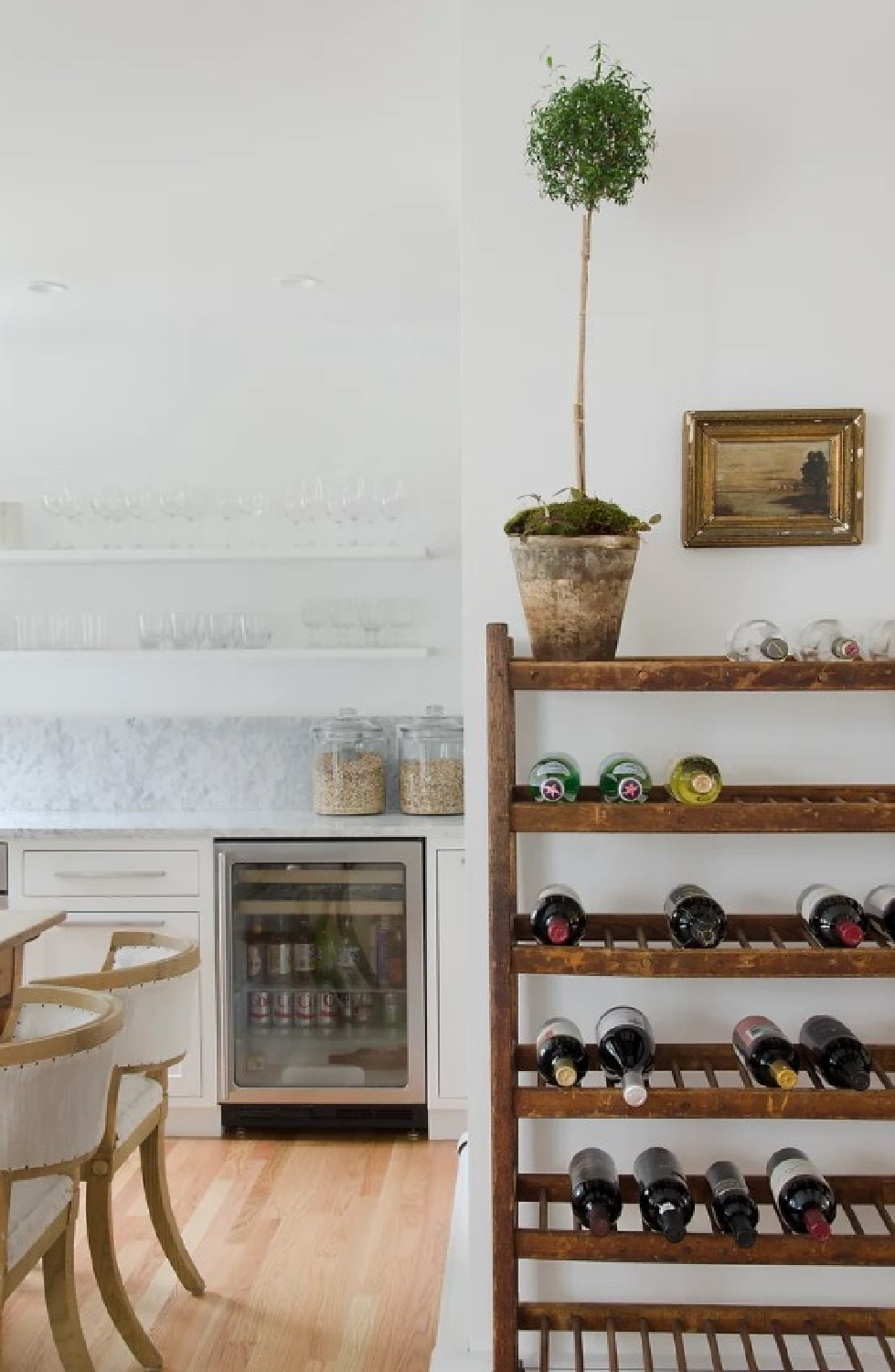 Chic modern country white kitchen with vintage accents, white marble, wood floors, and design by Kelly McGuill. Photo by Tamara Flanagan. #warmwhitekitchens