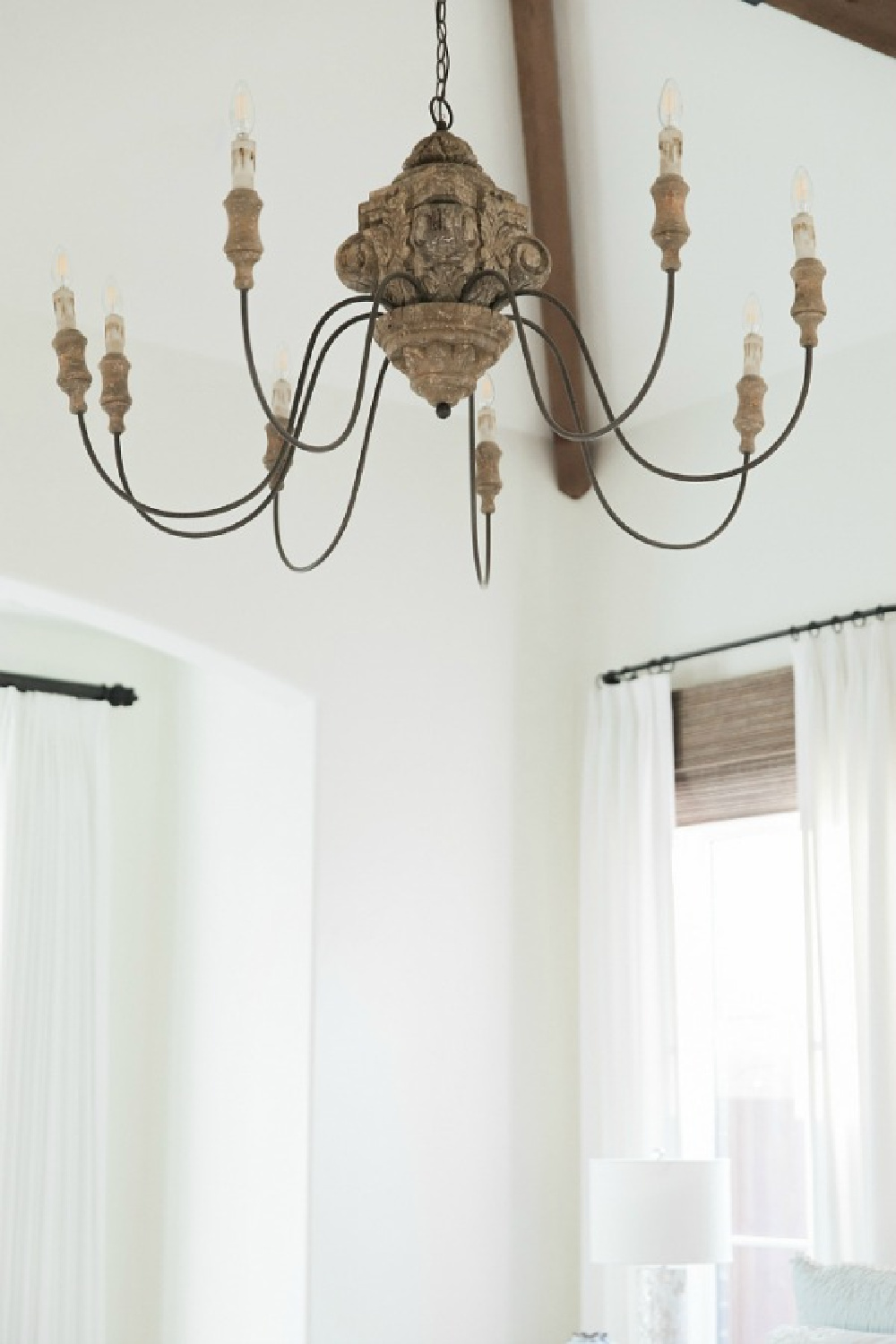 Detail of rustic French country chandelier in bedroom with Sherwin Williams Alabaster paint color. Brit Jones Design.