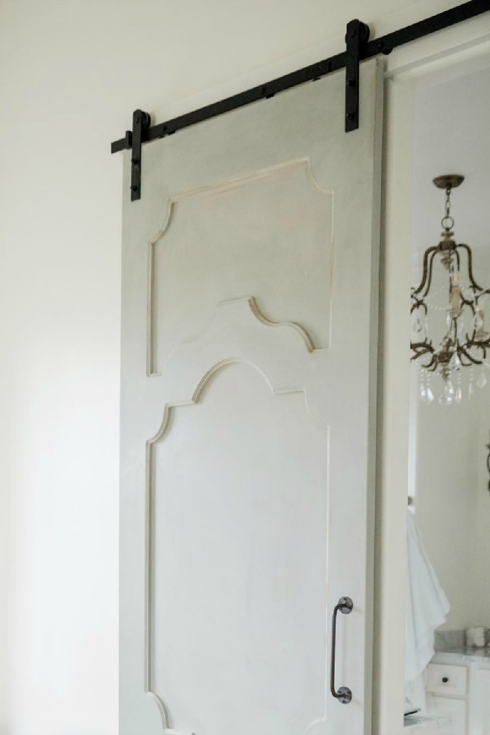 French country farmhouse bedroom with duck blue barn door and Sherwin Williams Alabaster paint color on walls. Brit Jones Design.