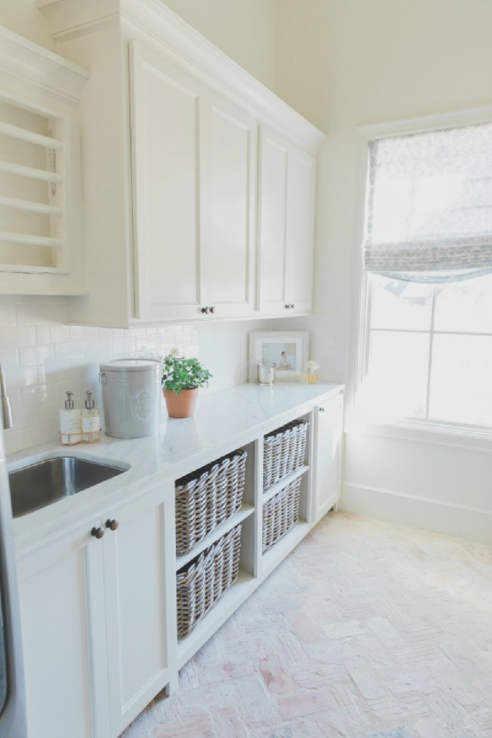 SW Alabaster painted laundry room with reclaimed brick flooring in herringbone pattern.