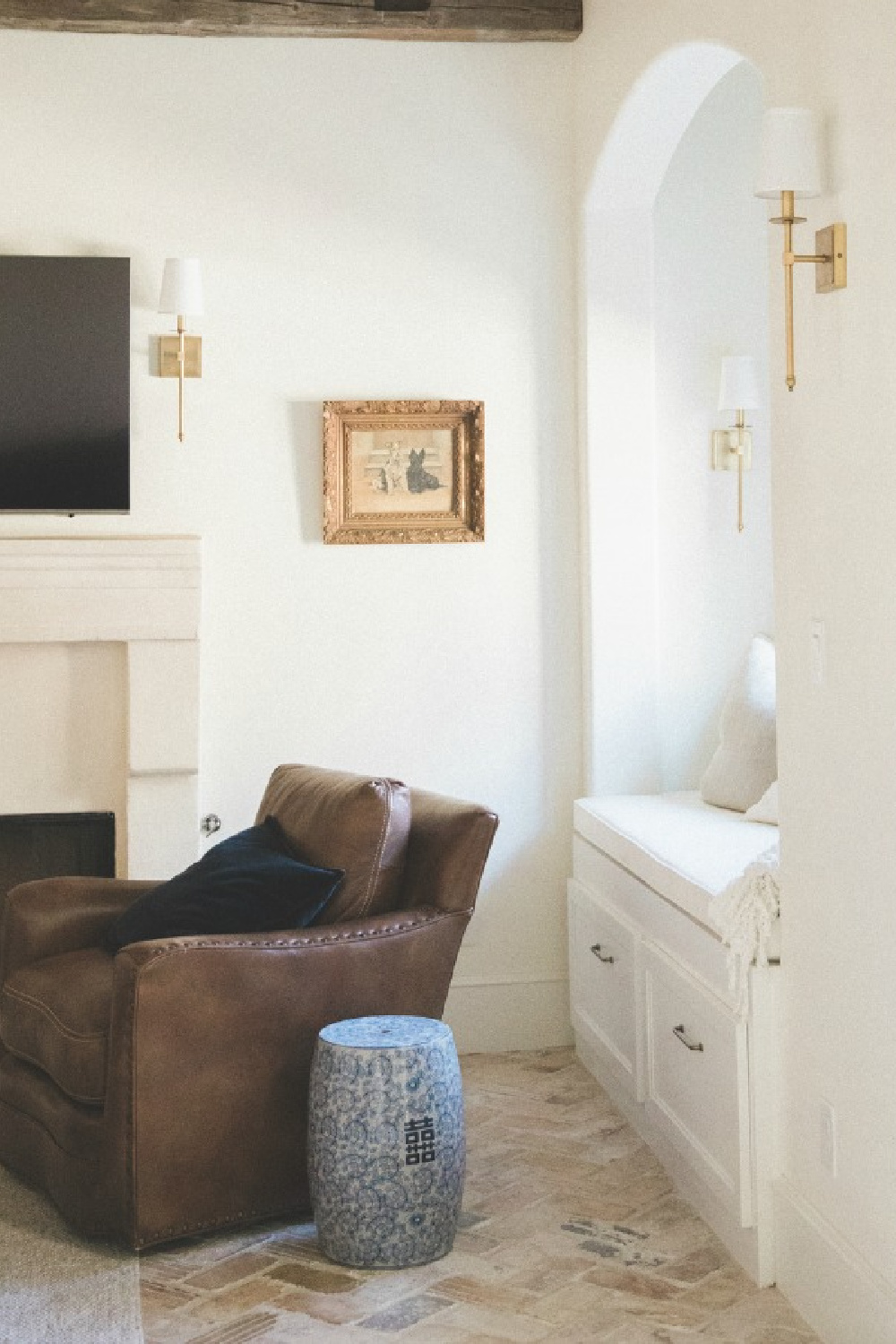 Cozy den with window seat nook and leather chair in a French country farmhouse by Brit Jones Design.