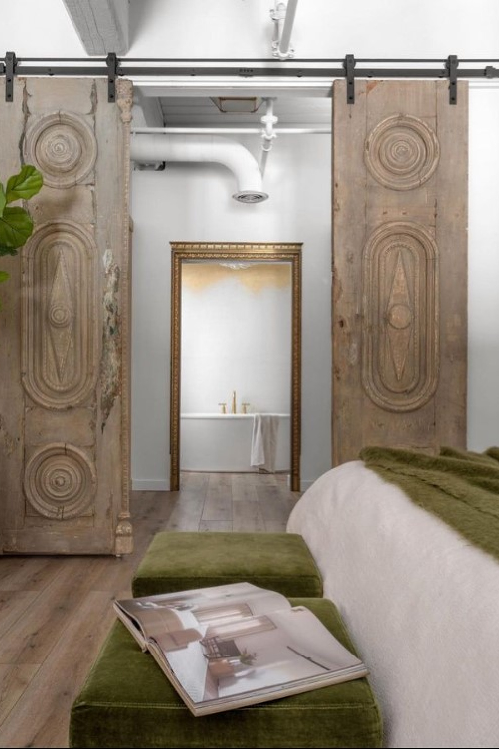 Sliding antique doors lead to a luxurious bath in beautiful Alison Victoria designed Atlanta loft on HTV's Windy City Rehab. Photo: Rustic White Interiors; Styling: Courtney Favini. House Beautiful.