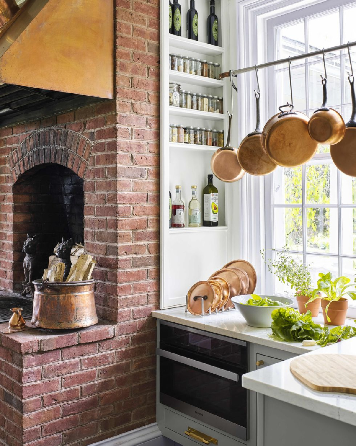 Beautiful country kitchen by Beekman 1802 (photo by Annie Schlechter) with brick, copper pans, and built-ins for spices. #countrykitchens