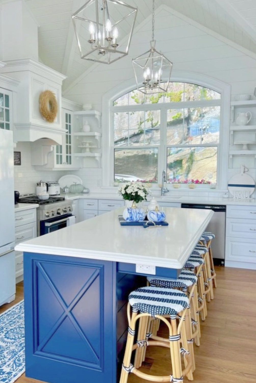 Beautiful white kitchen with blue island by @jubileehavencottage painted BM Decorator's White paint color. #decoratorswhite #bmdecoratorswhite