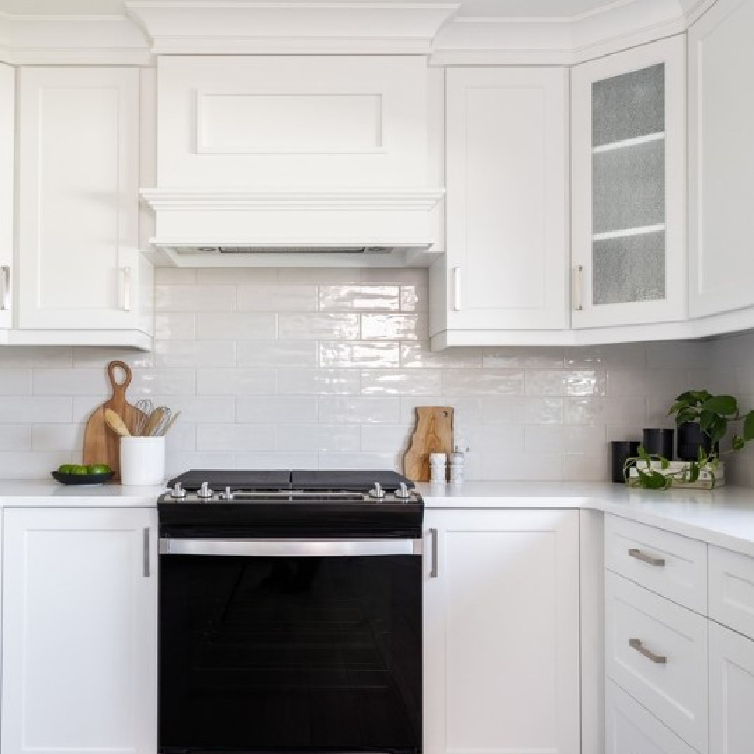 White kitchen by Oak Barrel Cabinetry with subway tile, black range, and BM Decorator's White paint color. #decoratorswhite #bmdecoratorswhite