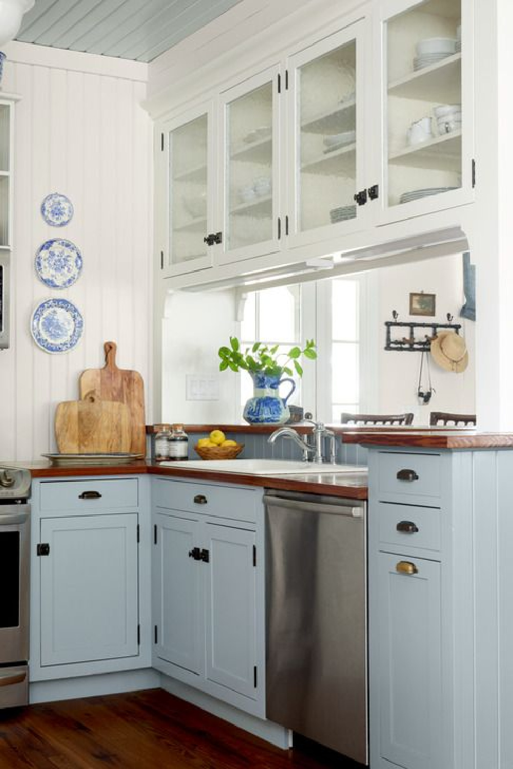 Blue kitchen base cabinets and white uppers in a beautiful country design - photo by David Hillegas. #bluekitchens #lightbluekitchen
