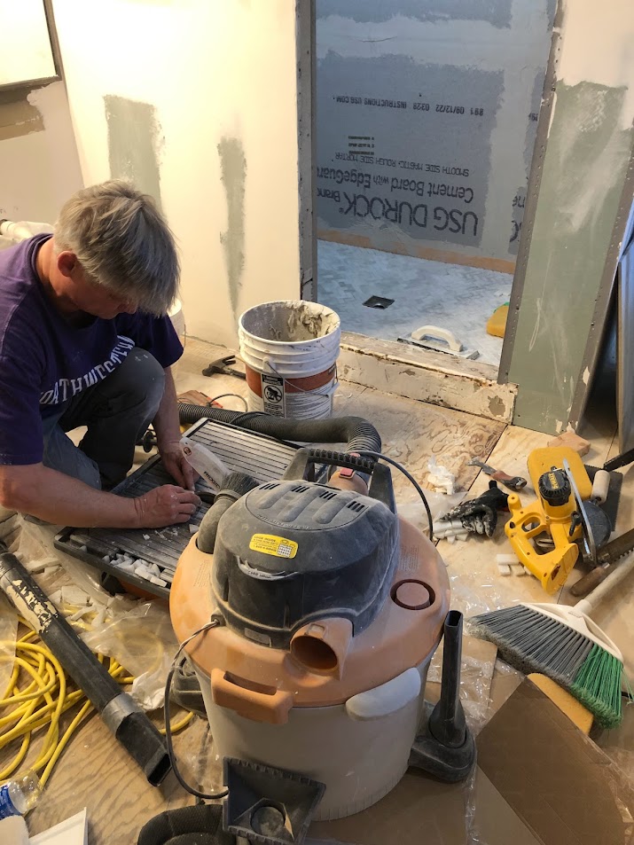 Cutting tiles during bath renovation at the Georgian - Hello Lovely Studio.