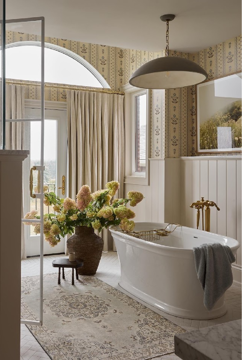 Tongue and groove paneling in a classic bath design with soaking tub and abundant natural light.