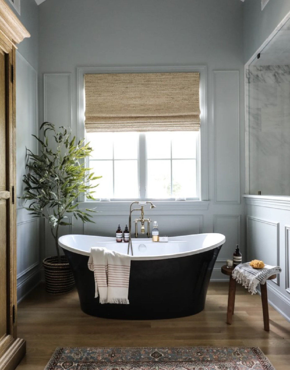 Beautiful classic bath with grey walls, oval soaking tub, and wood floor - Park and Oak.