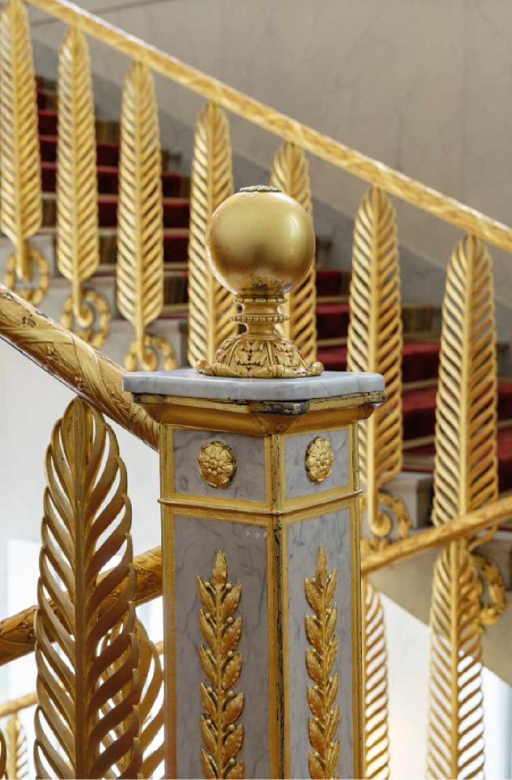 Élysée Palace main staircase banister of upright palm leaves rising from rosettes set within olive wreaths is made of bronze- and gold-plated lead. Photo by Ambroise Tézenas from Presidential Residences in France (Flammarion 2021)