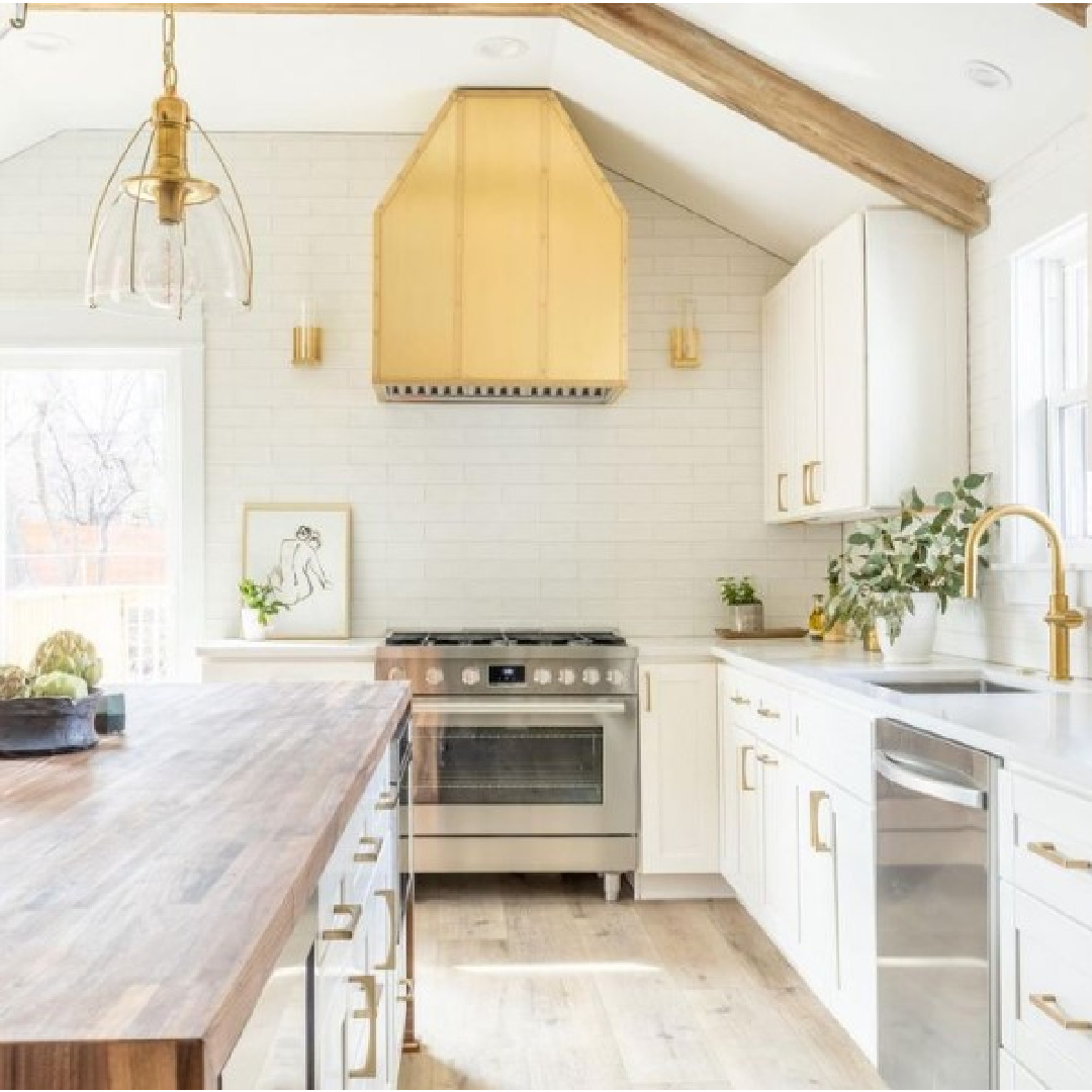 Alison Victoria Windy City Rehab season 3 renovated white kitchen with brass hood and butcher block topped island.