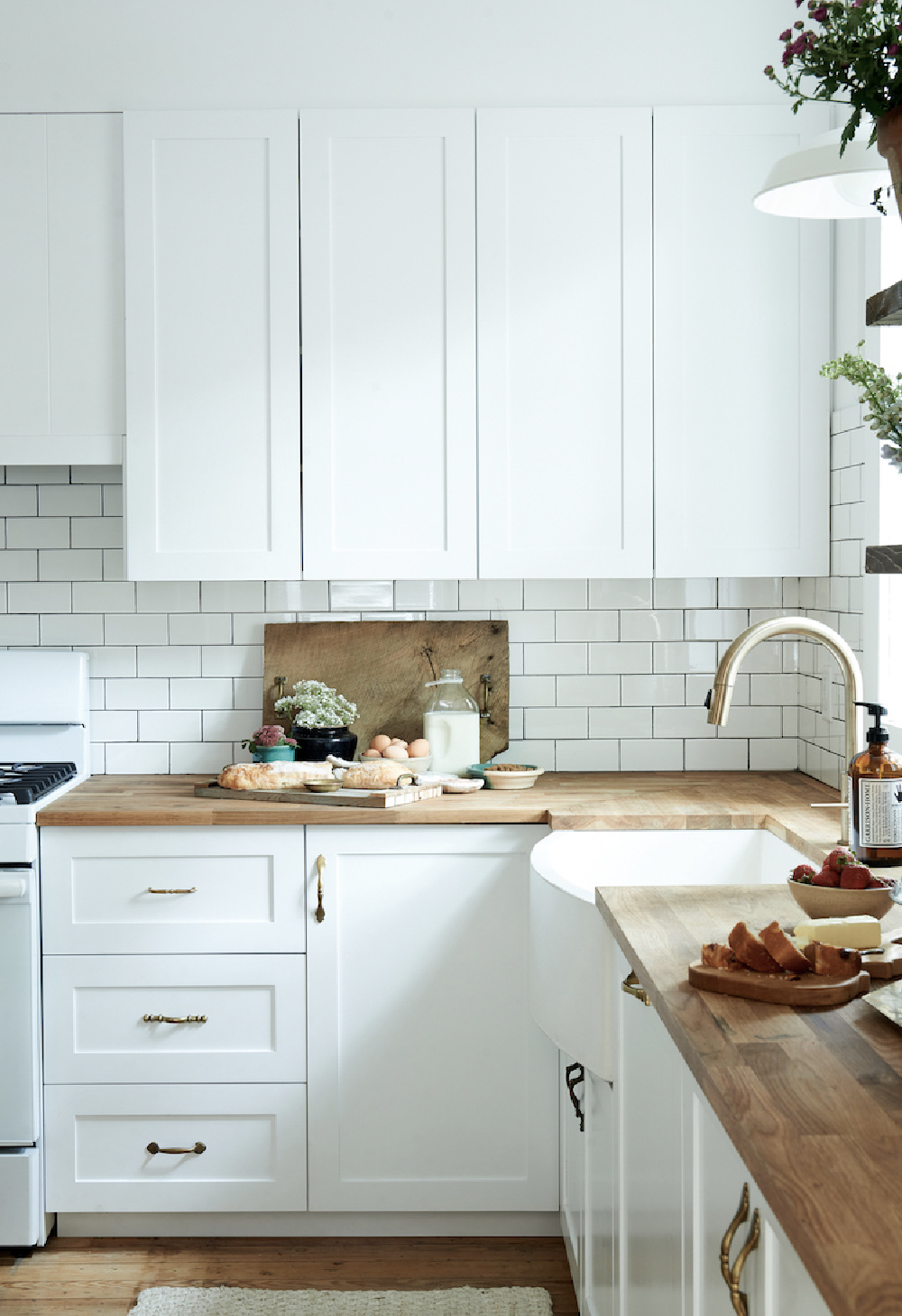 Leanne Ford designed modern farmhouse kitchen with farm sink, subway tile and butcher block counters. Photo: Alexandra Ribar. #leanneford #restoredbythefords #interiordesign #modernfarmhouse #farmhousekitchen #kitchendesign