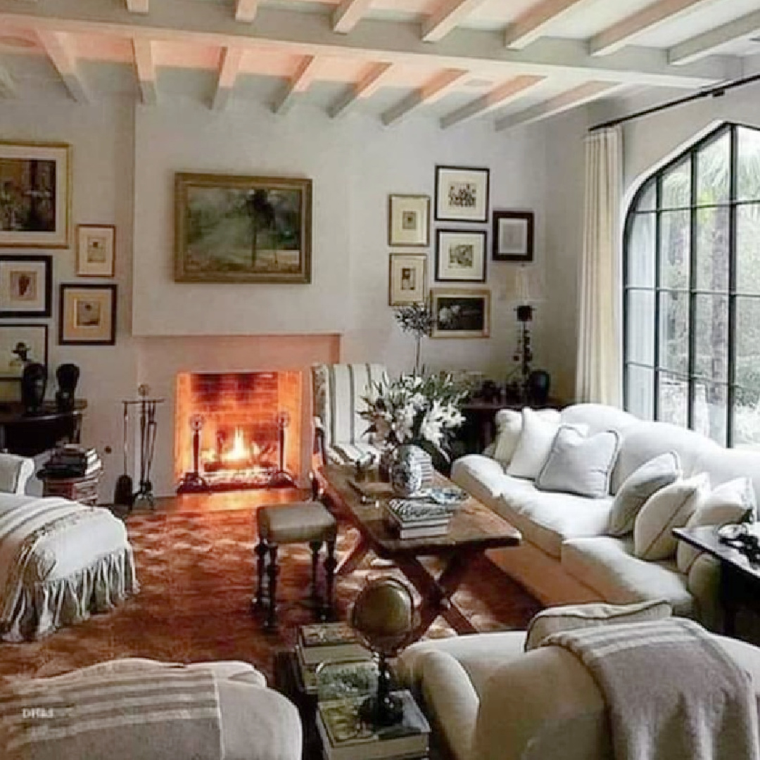 Charming English country living room with fire going, framed art flanking fireplace, and soothing neutrals - English Country Shabby. #englishcountrystyle #livingrooms